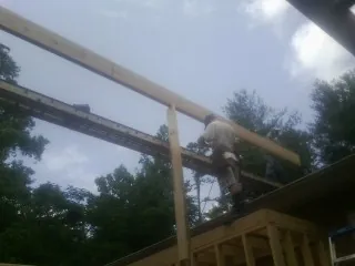 Carpenter setting a ridge beam over a new addition frame — Ice Dam Removal by Roofing Brothers in Sheakleyville