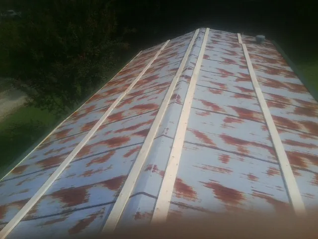 Rusted metal roof panels with new wood purlins before replacement — Storm Damage Roof Repair in Sheakleyville by Roofing Brothers