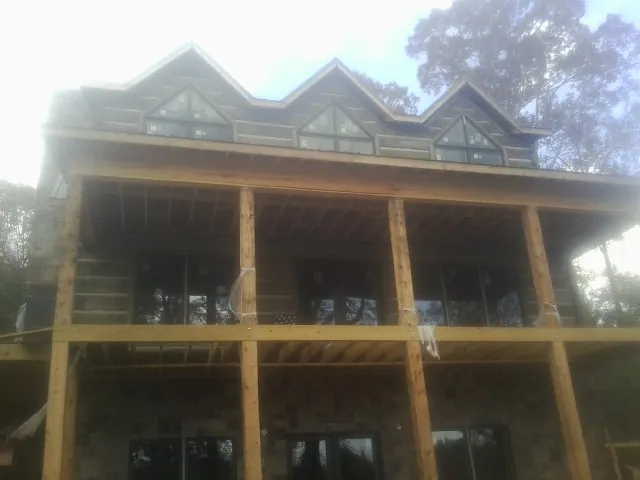 Dormers and porch framing on a large log home under construction — Roof Coating work by our crew in Sheakleyville