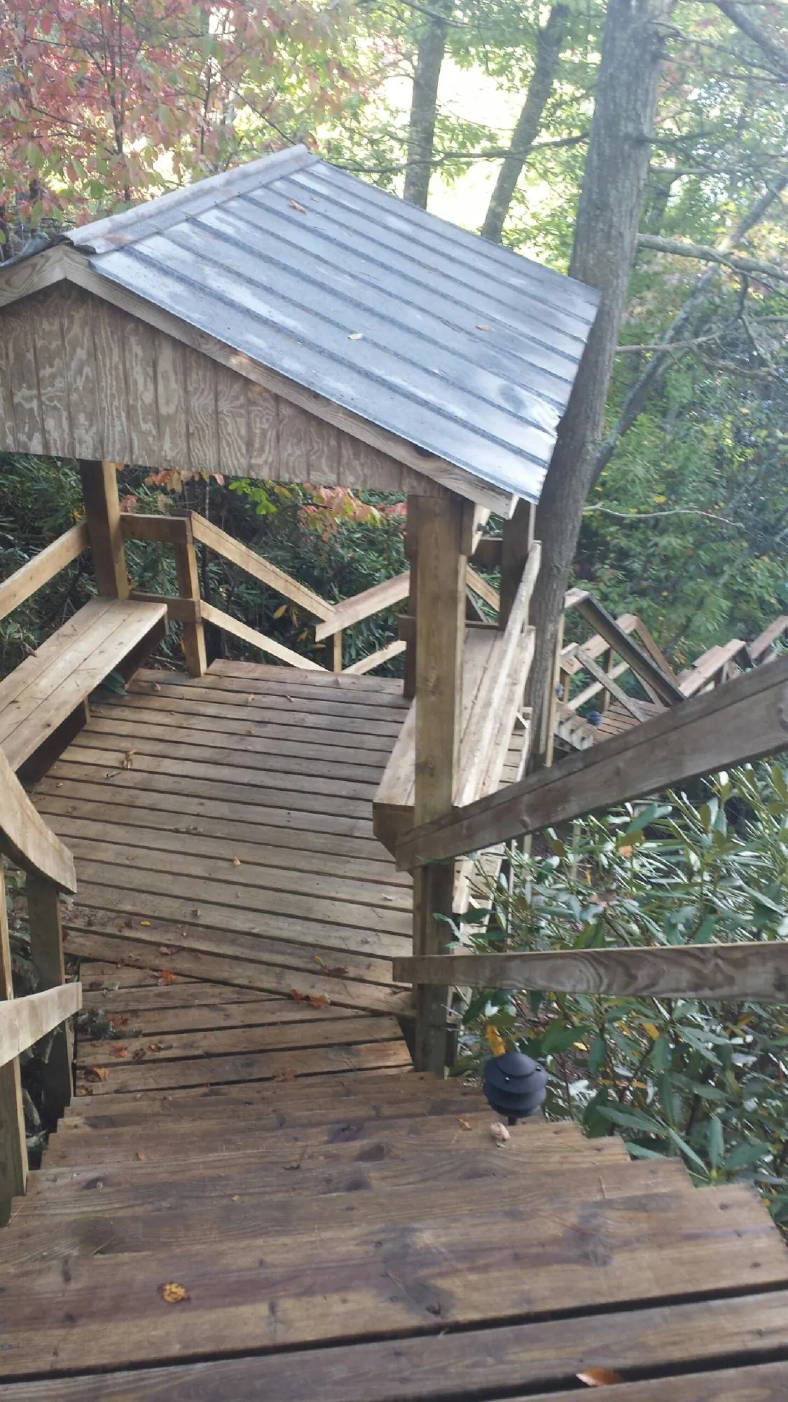 Metal roofed shelter over wooden steps on a wooded walkway — Skylight Repair & Installation work by our crew in Sheakleyville