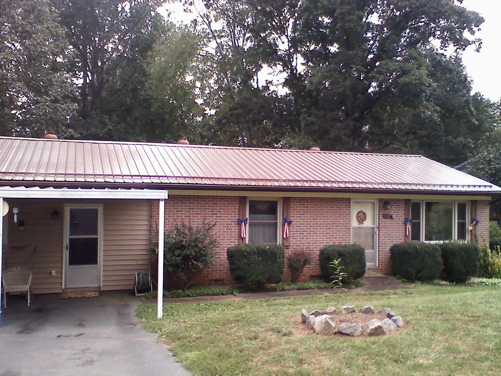 Bronze metal roof and carport on a brick ranch home — Roof Repair work by our crew in Sheakleyville