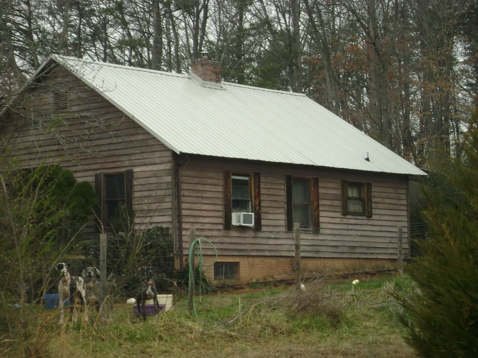 White metal roof on an old wood sided farmhouse, from a Metal Roof Installation job in Sheakleyville